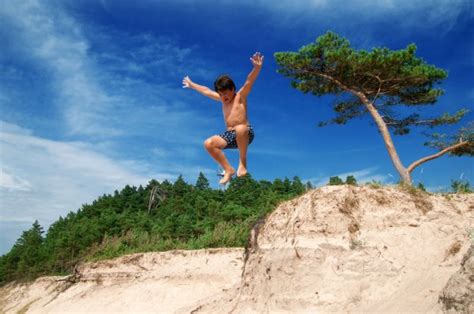 Boy Jumping Off Cliff Stock Photo by ©silaped 50893515