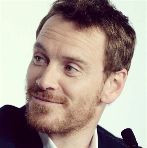 A Close Up Of A Person Wearing A Suit And Tie With A Smile On His Face