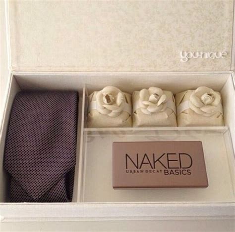 An Opened Box Containing Three Ties And A Tie Bar With The Word Naked