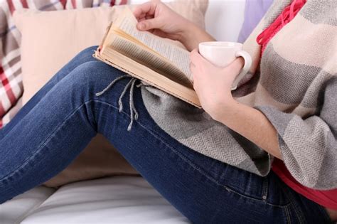 Mujer Sentada En El Sof Leyendo Un Libro Y Bebiendo Caf O T De Cerca