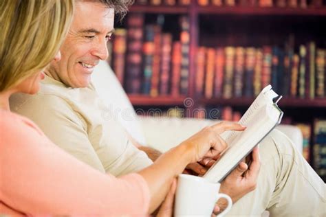 Pares Felizes Que Leem Um Livro Em Uma Sala De Leitura E Que Bebem O