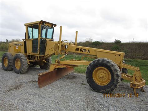 A Large Yellow Tractor Parked On Top Of A Gravel Road