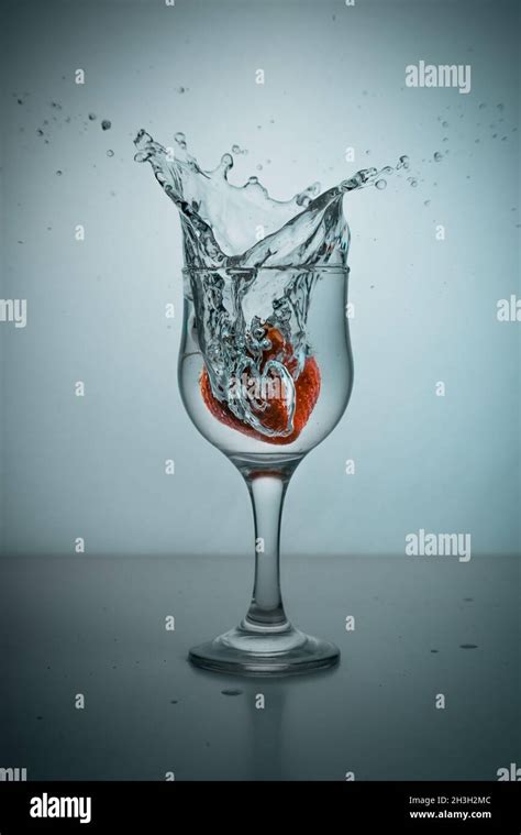 A Strawberry Dropped Into A Glass Of Water Stock Photo Alamy