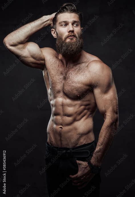 Brutal Bearded Guy With Naked Torso And Muscular Build With Hand In Pocket And Hand Under Head