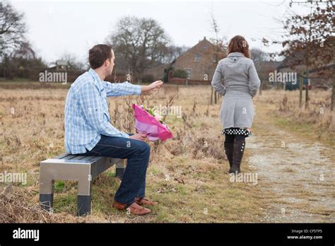 Woman walking away after a fight from her man in the field Stock Photo