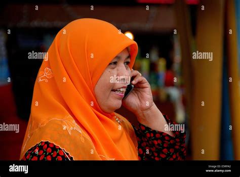 Singapore Muslim Woman Wearing Orange Head Scarf Talks On Her Cell