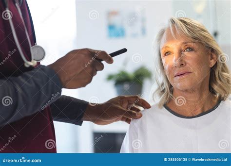 African American Male Doctor Examining Senior Female Caucasian Patient