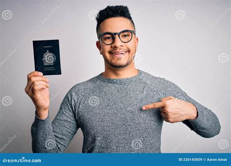 Young Handsome Tourist Man On Vacation Wearing Glasses Holding Canada