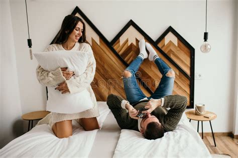 Happy Couple Laughing While Lying In Bed In Their Cozy Bedroom Sharing