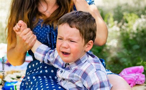 Mother Comforting A Crying Baby A Baby Is Crying In The Garden His