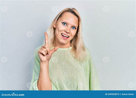 Beautiful Caucasian Blonde Woman Wearing Casual Winter Sweater Smiling