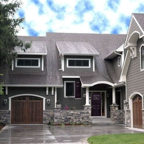 Dark Grey House With White Trim Wooden Looking Garage Door And A Dark