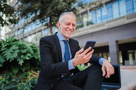 Premium Photo Smiling Mature Businessman With Suit Using A Modern