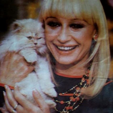 A Woman Holding A White Cat In Her Hands