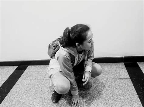 Premium Photo High Angle View Of Girl Crouching At Floor Against Wall