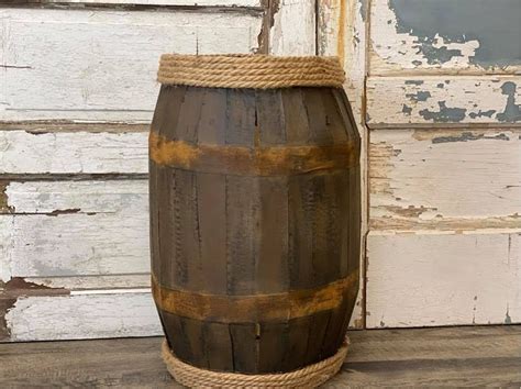 An Old Wooden Barrel With Rope Hanging From It S Side On A Wood Floor