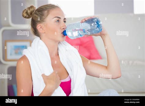 Thirsty Blonde Sitting On Exercise Mat Drinking From Water Bottle Stock Photo Alamy