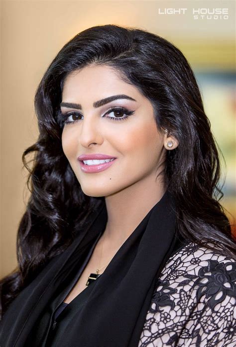 a woman with long dark hair wearing a black dress and earrings, smiling ...