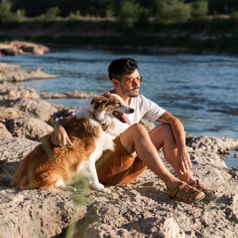 Hombre Joven Con Perro En La Playa Foto Premium