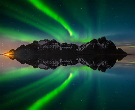 Luces del norte en la montaña vestrahorn y la playa de stokksnes