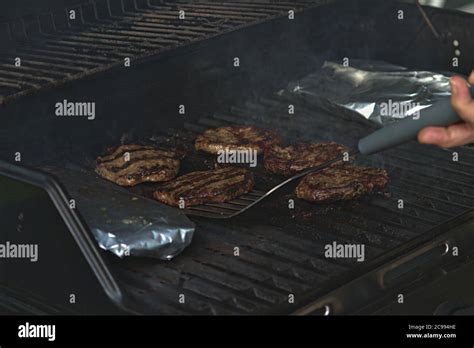 Person Flipping Burgers On The Barbeque With Flames Stock Photo Alamy