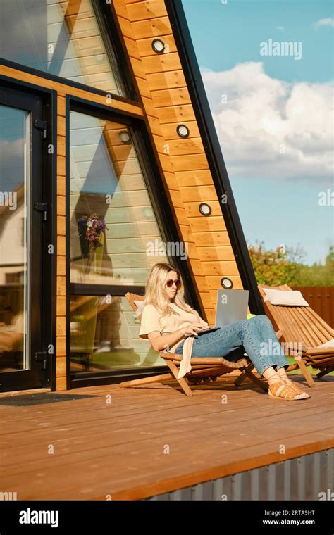 Mid Adult Woman Scrolling Social Media On Laptop While Laying In A