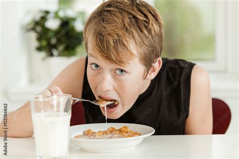 Teenage Boy Eating Breakfast Cereal In Morning Stock Photo Adobe Stock