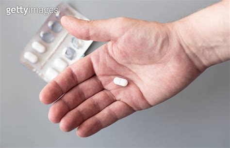 Close Up Male Palm With A Tablet Man Holding A White Pill In His Hand