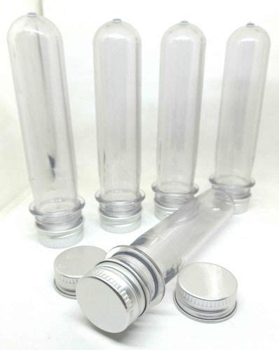 Four Clear Glass Bottles With Silver Caps On A White Surface One Is