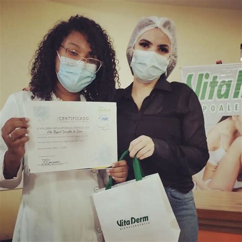 Two Women Wearing Masks And Holding Shopping Bags In Front Of A Sign