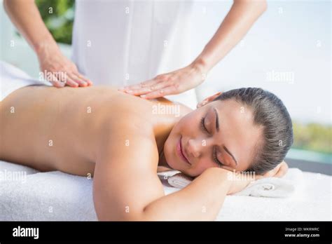 Happy Brunette Getting A Massage Poolside Outside At The Spa Stock