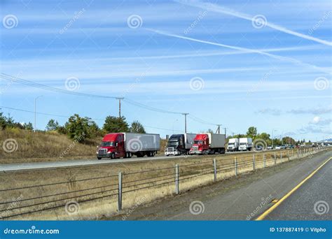Big And Small Rigs Semi Trucks Convoy Running On Divided Highway With