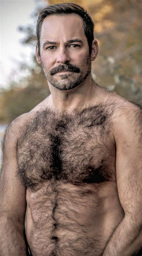 A Hairy Man With No Shirt On Posing For The Camera