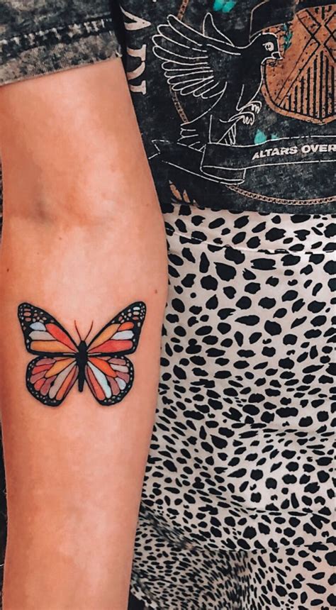 A Woman S Arm With A Butterfly Tattoo On The Left Side Of Her Body