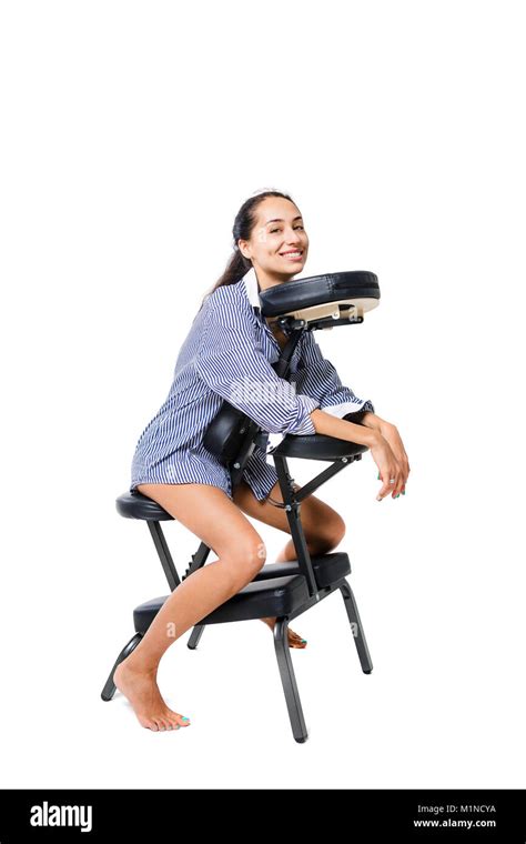 Jeune fille belle brunette employée de bureau dans une chemise et avec les jambes nues assis sur