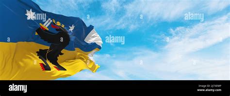 official flag of Satakunta , Finland at cloudy sky background on sunset ...