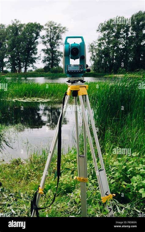 Blue Surveying Equipment Total Station On A Background Of Lake And