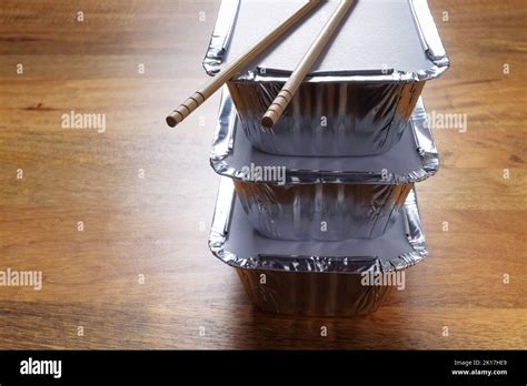 Stack Of Silver Foil Takeaway Trays With Chopsticks Placed On Top Stock