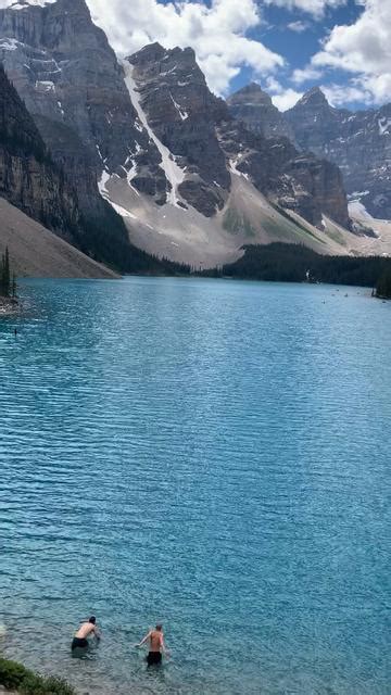 Two Men Swimming In The Mountains With Green Blue Glacier Water Gridbank