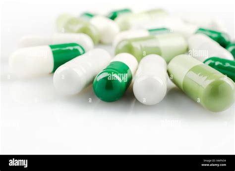 Medical Theme Bright White And Green Capsules On The White Surface