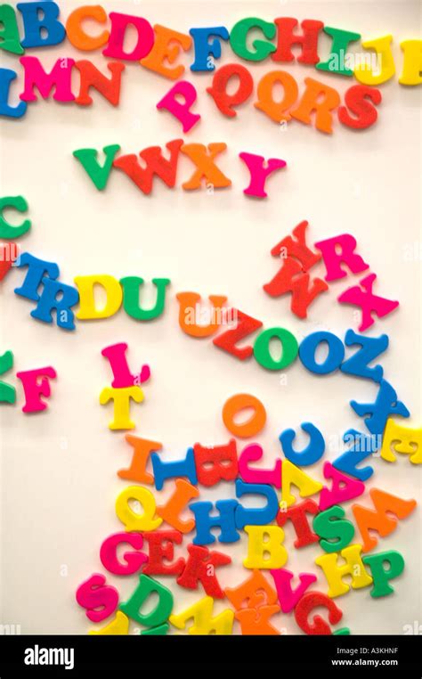 A jumble of colorful magnetic alphabet letters on a white board in a ...