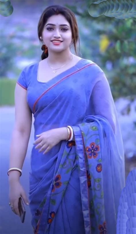 A Woman In A Blue Sari Is Posing For The Camera