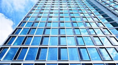 Un Edificio Con Una Fachada De Cristal Azul Y La Palabra Ventanas En