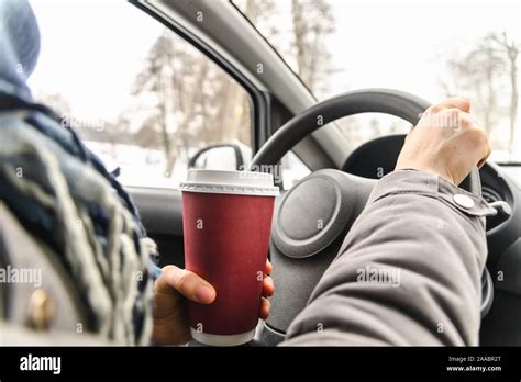 Driver Drinking Coffee In The Car Driving And Holding A Steering Wheel