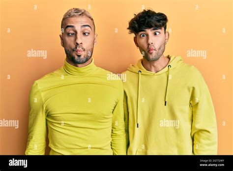 Homosexual Gay Couple Standing Together Wearing Yellow Clothes Making Fish Face With Lips Crazy