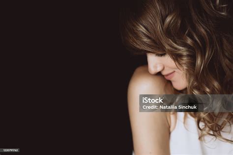 Portrait Of A 36 Years Old Woman With Curly Hair And Brown Slanting