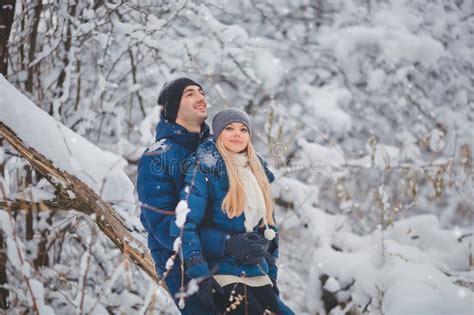 Счастливые пары имея потеху Outdoors в парке снега снеговик песка океана пляжа предпосылки