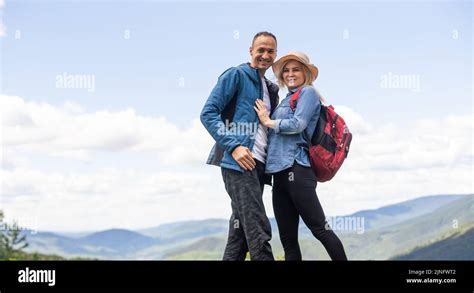 Rear View Of Hiking Couple With Backpack Standing Together On Hill Top