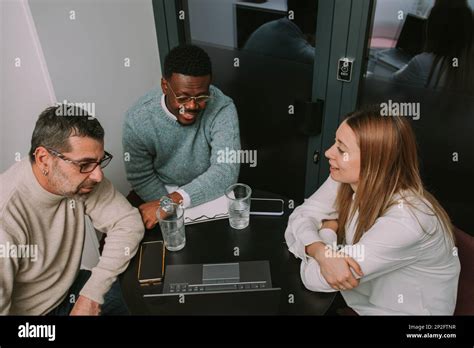 Gorgeous Blonde Female Business Person Presenting The New Sales Plan To Her Multiracial Male