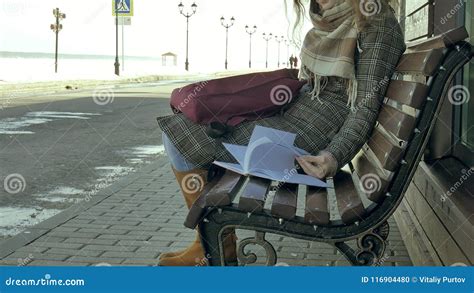 Jeune Belle Belle Femme Sasseyant Sur Le Banc En Parc Dans Des Mains De Son Carnet Elle